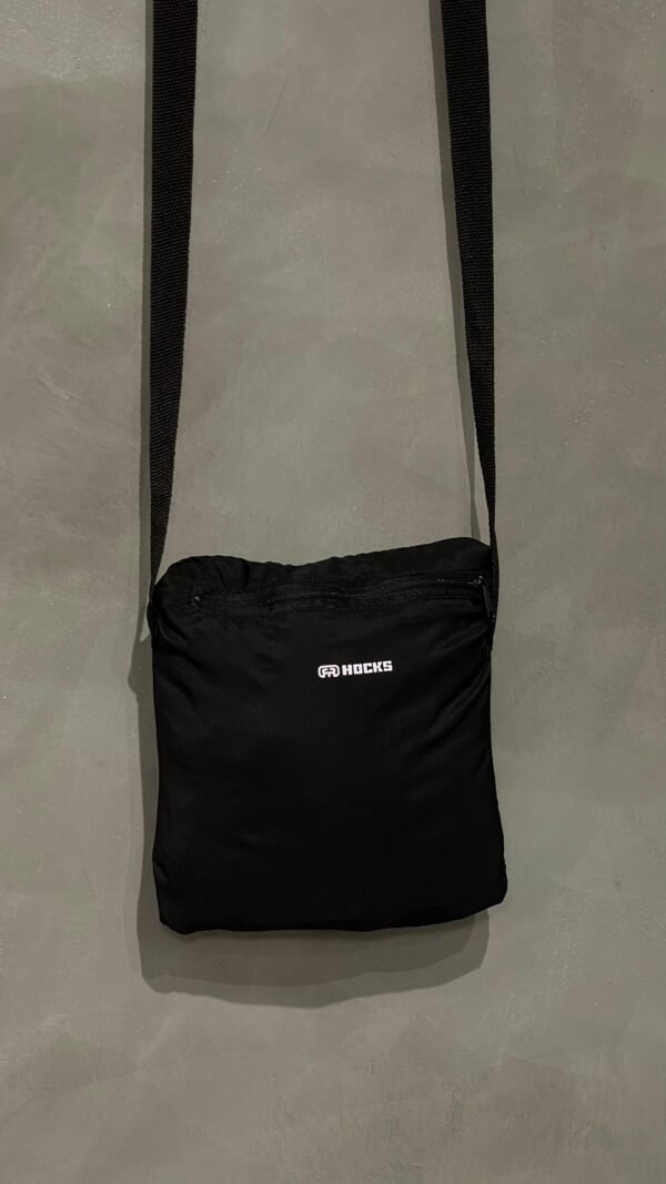 Jaqueta corta vento Hocks com logo refletivo na cor preta, ideal para proteção e estilo urbano.