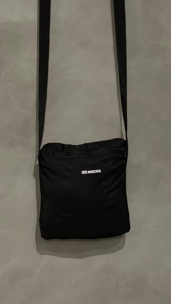 Jaqueta corta vento Hocks com logo refletivo na cor preta, ideal para proteção e estilo urbano.