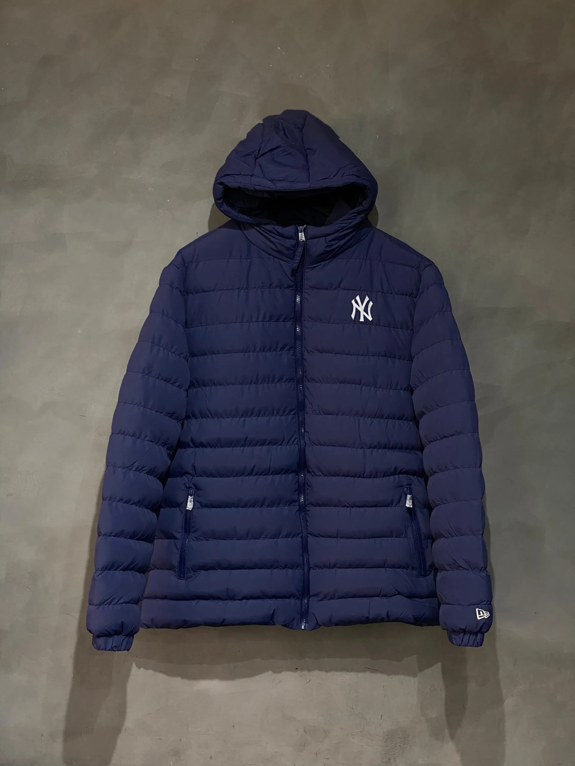 Jaqueta Puffer New Era NY na cor azul marinho, ideal para estilo e proteção nos dias frios.