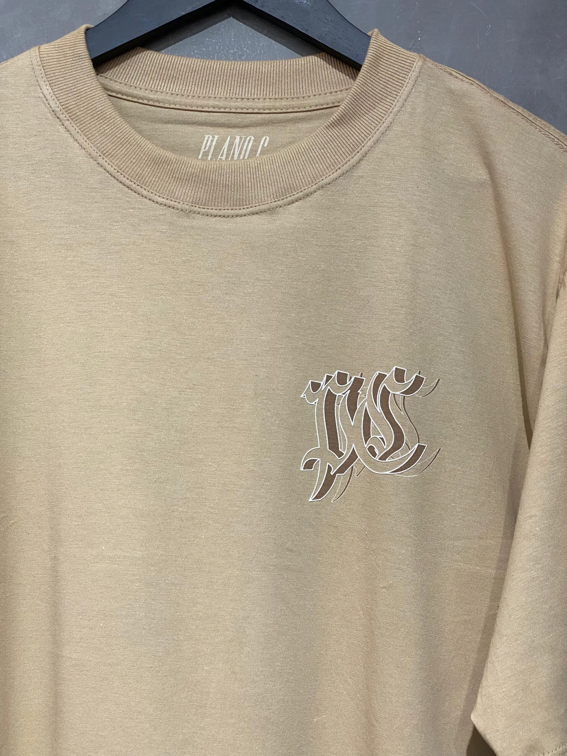 Camiseta Plano C. PC Outline bege, modelo oversized com algodão de alta gramatura para conforto e durabilidade.