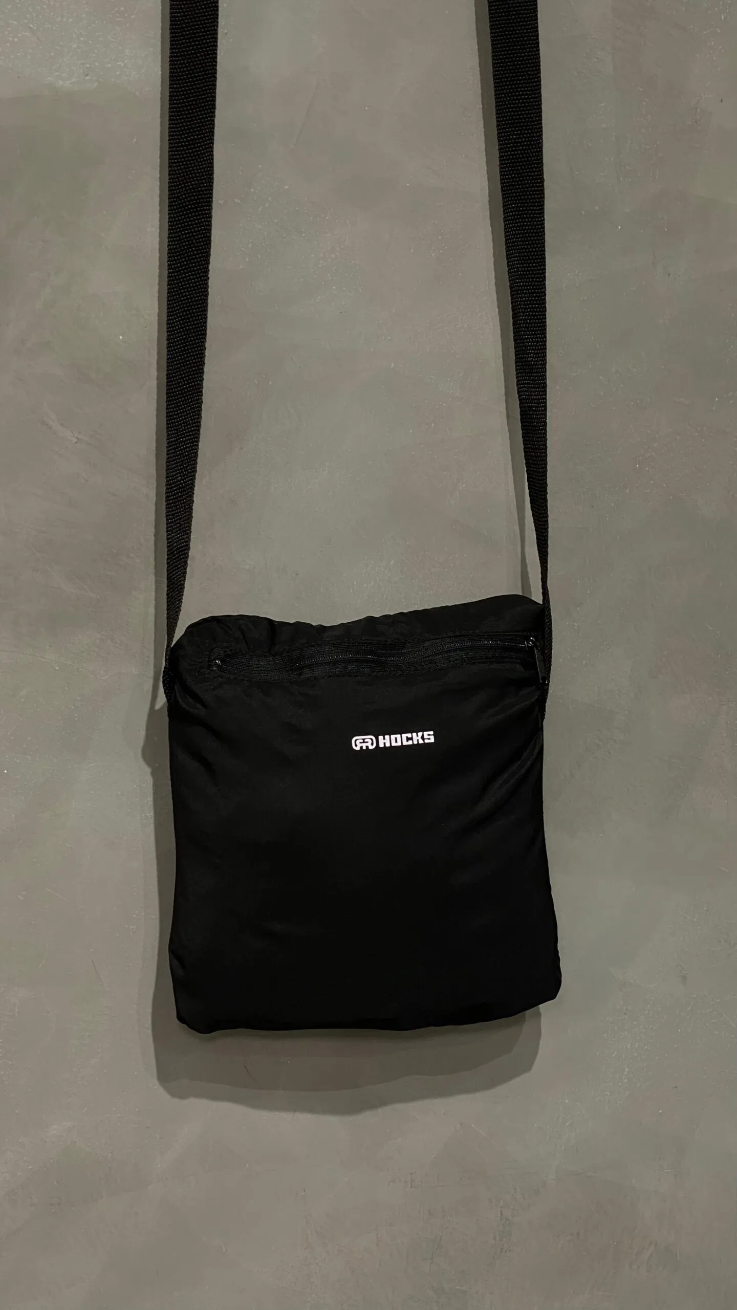 Jaqueta corta vento Hocks com logo refletivo na cor preta, ideal para proteção e estilo urbano.