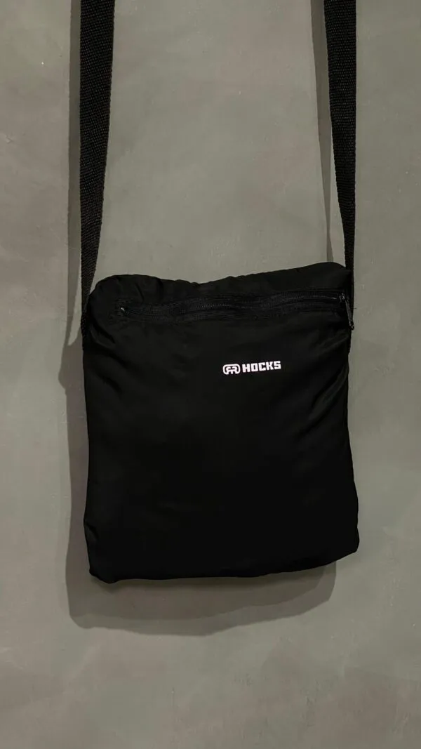 Jaqueta corta vento Hocks com logo refletivo na cor preta, ideal para proteção e estilo urbano.